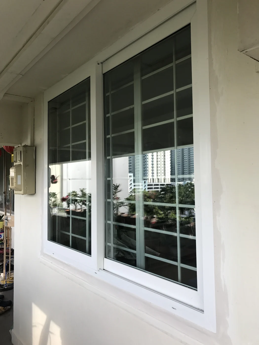White aluminium sliding windows with security grilles installed in Singapore